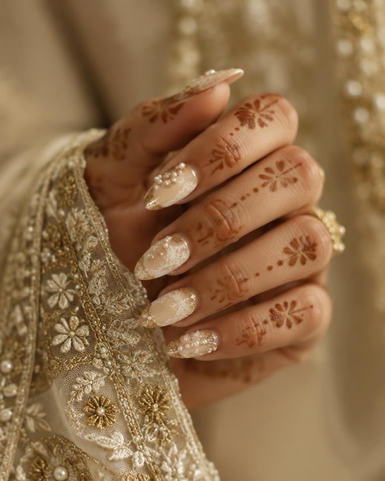 Ivory bridal nails with pearls and lace detail beside mehendi