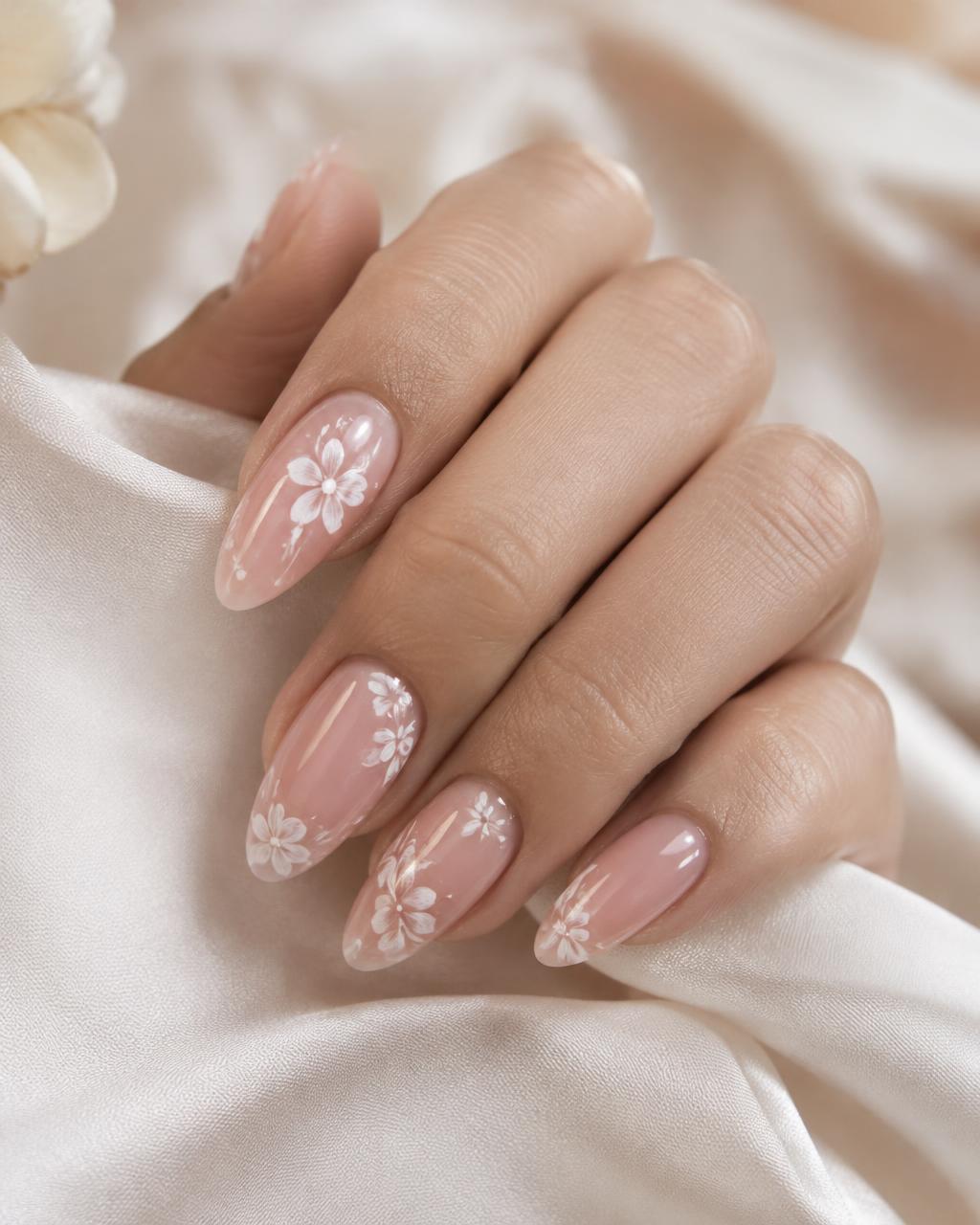 Almond nude-pink nails with white hand-painted flowers
